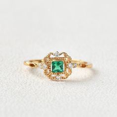 Heirloom Diamond Promise Ring For May Birthstone, Emerald Cluster Ring With Diamond Accents For Gifts, Heirloom May Birthstone Cluster Ring For Promise, Heirloom Emerald Ring With Halo Design For Promise, Heirloom Style Emerald Ring With Halo Design For Promise, Heirloom Emerald Ring With Cubic Zirconia For Anniversary, Heirloom Cubic Zirconia Emerald Ring For Anniversary, Gold Emerald Ring With Halo Design For Anniversary, Gold Emerald Cluster Ring For Wedding