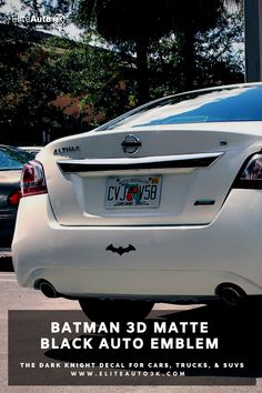 the back end of a white car with batman stickers on it's license plate