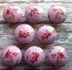 six pink roses are painted on the front and back of these knobs for cabinet doors