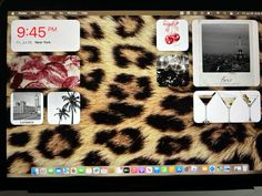 an open laptop computer sitting on top of a leopard print table cloth covered in pictures