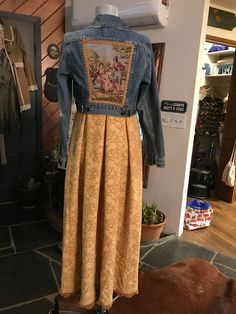 a woman's jean jacket and dress on display