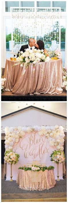 a couple kissing in front of a pink and gold wedding sign with flowers on it