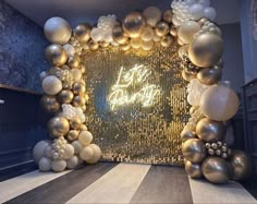 an entrance to a party decorated with gold and white balloons in the shape of a frame