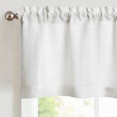 a white curtain hanging on the side of a window