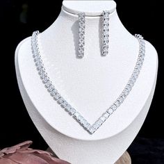 A beautiful three-piece bridal jewelry set that will add elegance and sophistication to any wedding gown or formal ensemble! Adorned with intricately faceted cubic zirconia that capture the light from every angle with a perfectly translucent appeal, the pieces are platinum / 14K yellow gold plated for a flawless finish which enhances the intricate detailing and conveys a modern take on old elegance. Necklace: 17.7" (approx. 45cm) long with a secure fold-over closure (a 2" extension chain can be Elegant Silver Wedding Sets, Hand-set Cubic Zirconia Party Sets, Elegant Cubic Zirconia Party Sets, Silver Crystal Wedding Sets, Silver Crystal Sets For Wedding, Elegant Diamond White Jewelry Sets With Rhinestones, Elegant Diamond White Jewelry Sets With Diamond Accents, Elegant Diamond White Jewelry Sets With Sparkling Stones, Dazzling White Crystal Bridal Sets