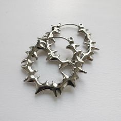 Elevate your style with these bold, spiky stainless steel hoop earrings. 100% high polished stainless steel, 1" diameter. The modern design features smooth spiky that add an edgy statement to any look. Made from durable stainless steel, these earrings have some weight to it, although comfortable for all-day wear, it might not be weight sensitive ears friendly. Add a touch of contemporary attitude to your ensemble with these standout hoops. We ship in 1-3 days, all purchases come with complimentary jewelry pouch and box. Edgy Pierced Hoop Earrings As Gift, Metal Hoop Plug Earrings, Punk Small Hoop Earrings As Gift, Nickel-free Surgical Steel Hoop Earrings, Nickel Free Surgical Steel Hoop Earrings, Edgy Hoop Earrings As A Gift, Edgy Small Hoop Pierced Earrings, Nickel-free Edgy Hoop Earrings, Punk Metal Earrings With Spikes