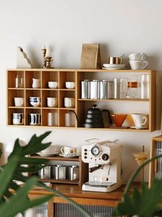 a coffee maker sitting on top of a wooden shelf