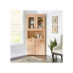 a wooden china cabinet with glass doors and drawers in a living room next to a window