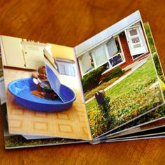 an open magazine on a wooden table in front of a house with a blue bowl