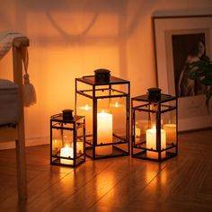 three lit candles sitting on top of a wooden floor