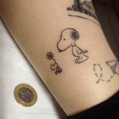 a person with a small tattoo on their arm that has a dog and flowers on it