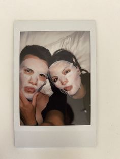 two women with white facial masks on their faces are posing for a photo in front of a mirror