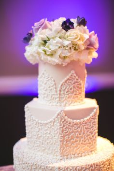 a white wedding cake with flowers on top