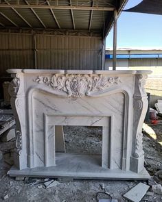 a white marble fireplace with carvings on it