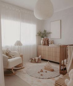 a baby's room with a crib, rocking chair and dresser in it