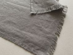 a piece of cloth with fringes laying on the floor