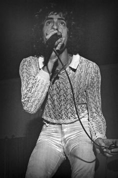 a black and white photo of a man singing into a microphone