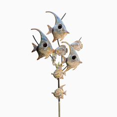 four fish are on top of a metal pole