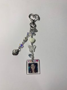 a keychain with a photo and charms attached to the clasp on it's side