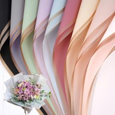 a bouquet of flowers sitting on top of a white table next to colorful wall paper