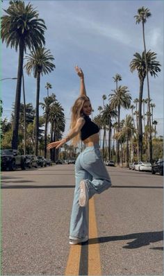 a woman is doing a skateboard trick in the street