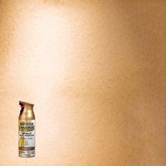 a can of spray paint sitting on top of a wooden table next to a wall