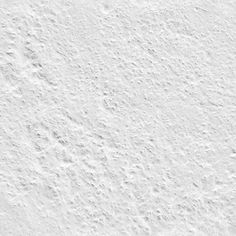 a white wall that has some kind of textured surface on it, with small dots in the middle