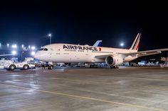 an airfrance jet sitting on top of an airport tarmac at night time