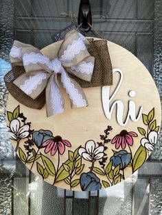 a wooden sign with flowers and lace on it