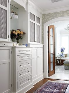 a bathroom with white cabinetry and floral wallpaper