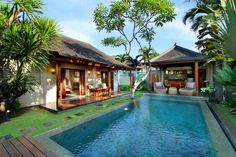 an outdoor swimming pool surrounded by palm trees