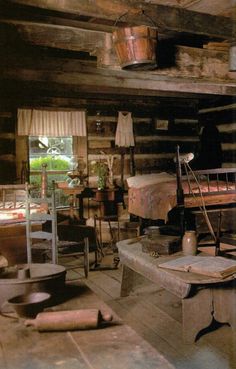 an old log cabin with lots of furniture