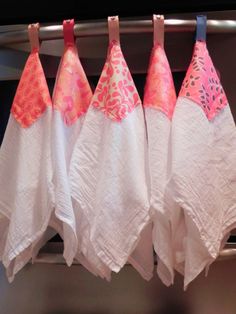 four white and pink towels hanging on a rack