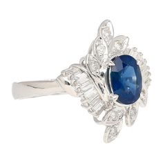 Natural Oval Cut Blue Sapphire and Diamond Platinum Floral Motif Ring.  This cocktail ring is crafted from a platinum 900 ring setting. The main stone is a natural blue sapphire with good transparency, color, and clarity. The sapphire is oval-cut with 1.52 carats in weight and a favorable spread that optically looks like a 2 carat gem. Adorning the sides of the sapphire are 8 round-cut diamonds and 14 triangular-cut diamonds. The diamonds share a carat weight of 0.52 total. The ring is sized at a USA 6.5. Ring is adjustable.   Item Details: - Type: Ring  - Metal: Platinum  - Weight: 6.35 grams  - Setting: Prong  - Size: 6.5  _______________________  Center Stone Details: - Type: Sapphire  - Carat: 1.52  - Cut: Oval  - Color: Blue  - Measurements: 8 X 6.4 mm  _______________________  Side S Blue Oval Diamond Ring With Polished Finish, Oval Blue Diamond Ring With Polished Finish, Oval Platinum Sapphire Ring, Floral Ring, Ring Setting, Ring Metal, Natural Blue Sapphire, Gem Stone, 2 Carat