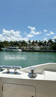 the back end of a boat traveling down a river with palm trees in the background