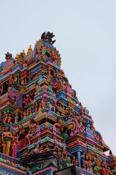 the top of a colorfully decorated building with statues on it