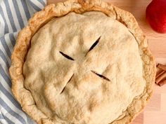 an apple pie with a knife sticking out of it's face on top of a wooden table