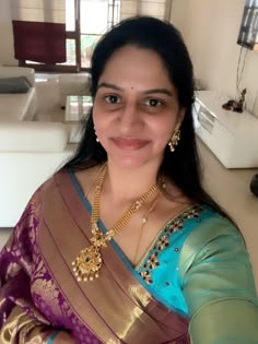 a woman in a sari is smiling for the camera