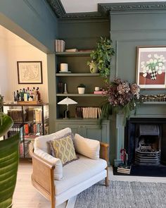 a living room filled with furniture and a fire place next to a book shelf full of books