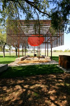 a red object is in the middle of a grassy area with trees and grass around it