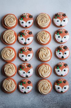 cupcakes with frosting decorated as foxes and deer's faces are arranged on a table