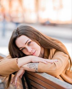 a woman sitting on top of a wooden bench