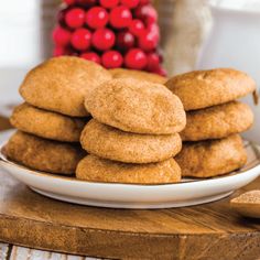 a stack of cookies sitting on top of a white plate next to a pile of cranberries