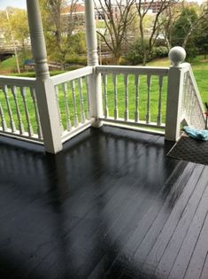 a porch with black wood floors and white railings