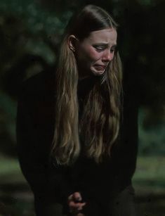 a woman with long hair standing in the dark