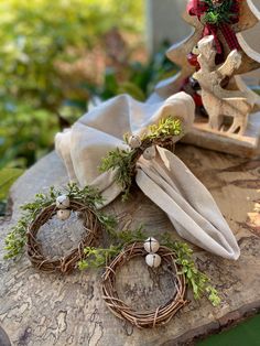 a table topped with wreaths and napkins on top of a piece of wood