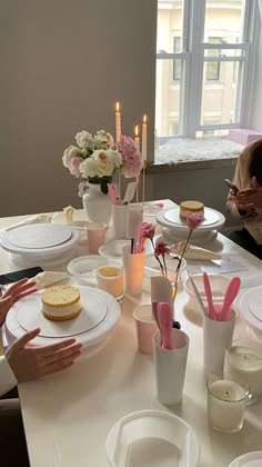 a group of people sitting at a table with plates and cups in front of them