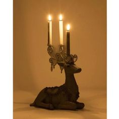 a deer figurine with three candles in it