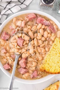 ham and bean soup in a white bowl with a piece of bread on the side