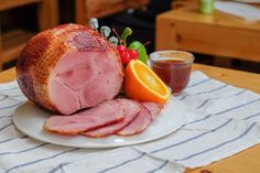 ham, oranges and juice on a white plate